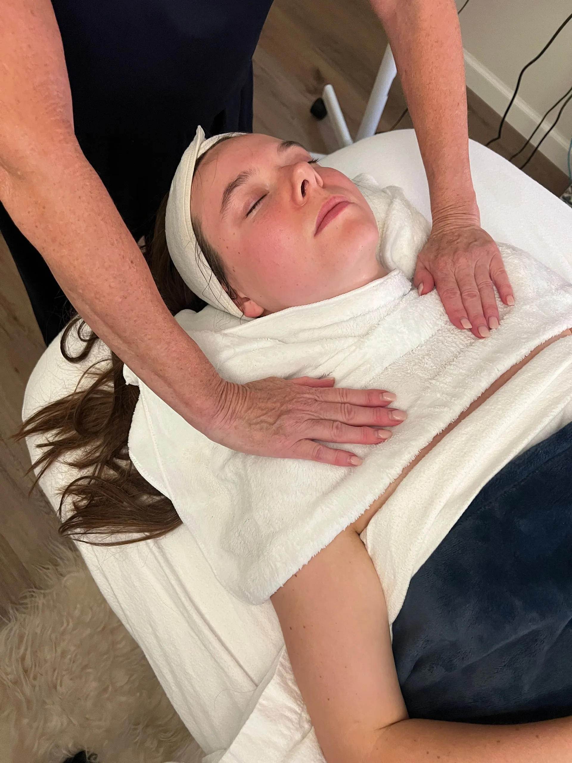 A woman is laying on a bed getting a massage.