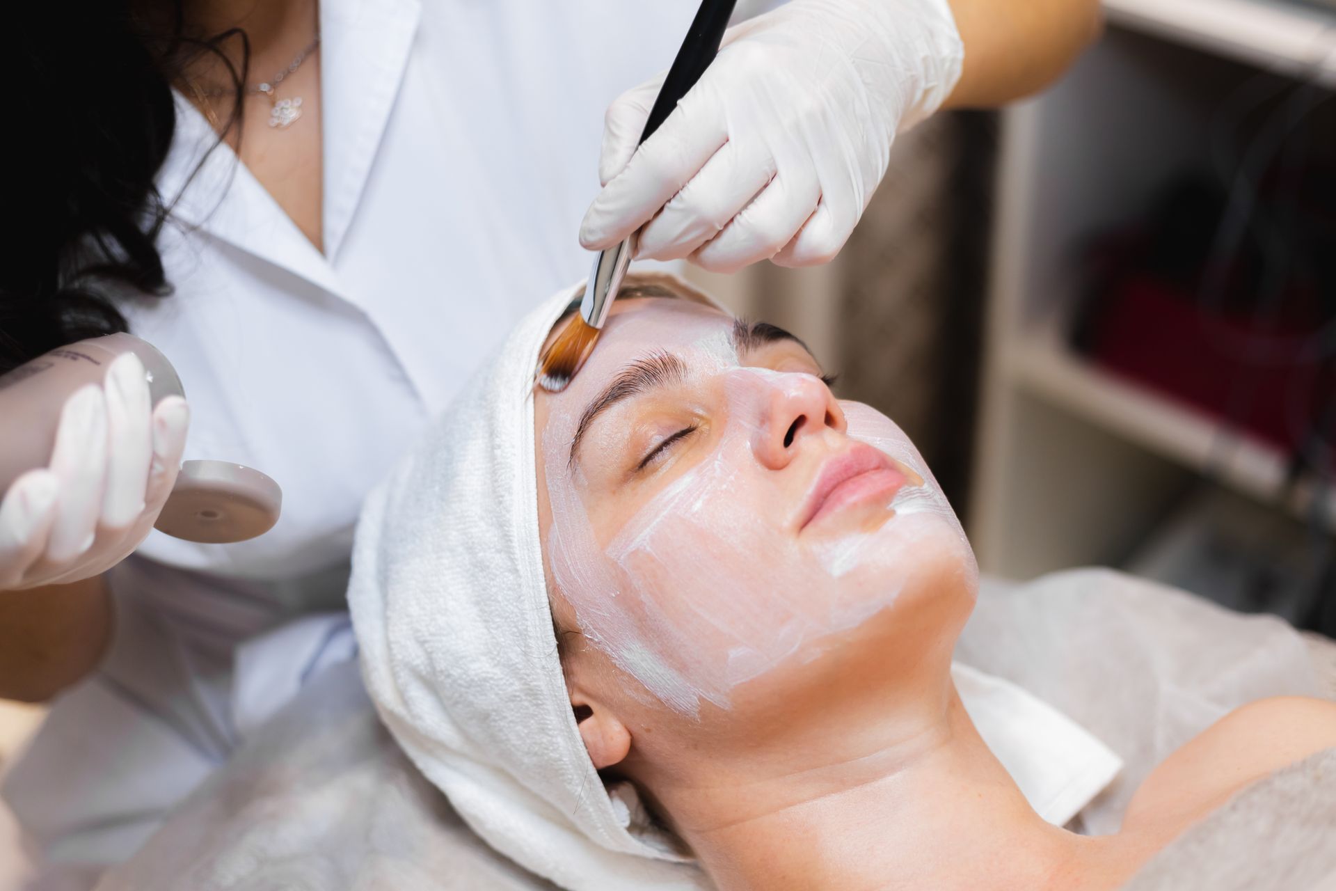 Facial treatment with a brush applied to a client's face in a spa setting