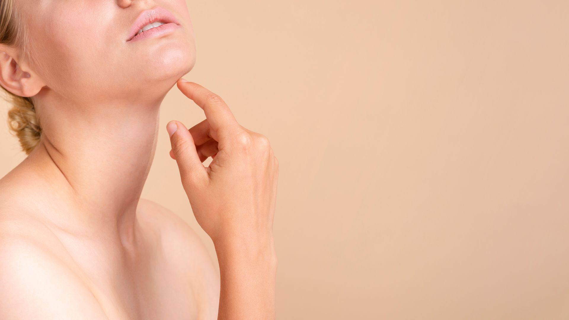 A woman is touching her chin with her hand.